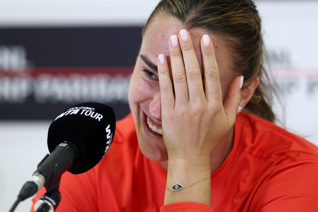 Aryna Sabalenka smiling, holding a bouquet of flowers in Rome